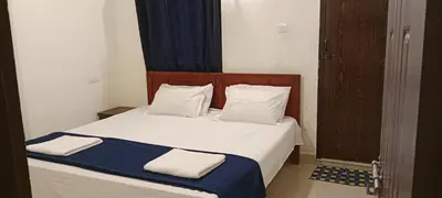 a bedroom with a bed with white sheets and pillows at Vythiri Garden in Vythiri
