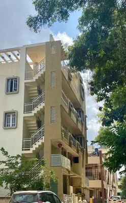 a building with balconies and a car parked in front of it at Spacious 2BHK for upto 12 Guests , Best for Families & Groups in Mysore
