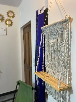 a hanging wall art in a room with a green chair at Spacious 2BHK for upto 12 Guests , Best for Families & Groups in Mysore