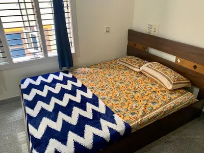 a bedroom with a bed with a chevron blanket on it at Spacious 2BHK for upto 12 Guests , Best for Families & Groups in Mysore