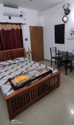 a large bed in a room with a table and chairs at Vyshnavi home stay in Thanniyam