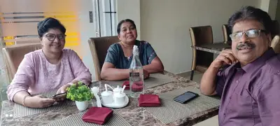 a group of three people sitting at a table at Vyshnavi home stay in Thanniyam