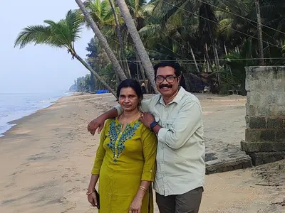 a man and a woman standing on the beach at Vyshnavi home stay in Thanniyam