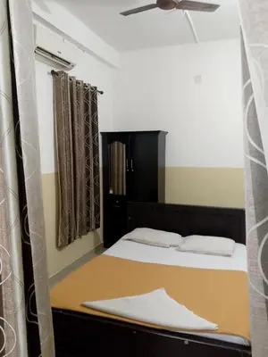 a bedroom with a bed and a ceiling fan at Lotus Grand Residency in Angādipuram