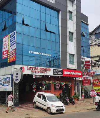 a white car parked in front of a building at Lotus Grand Residency in Angādipuram