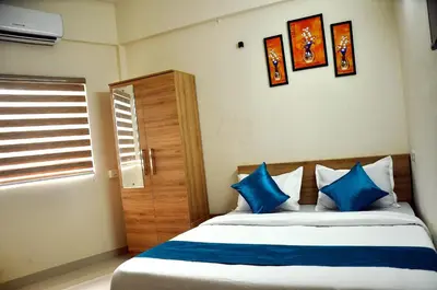 a bedroom with a bed with blue pillows and a window at MARHABA PALACE in Kozhikode