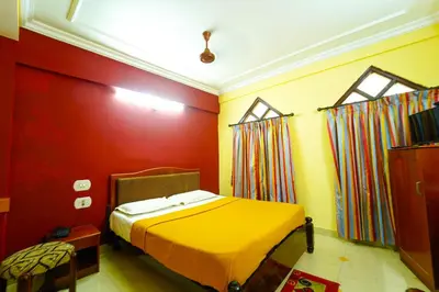 a bedroom with a yellow bed and red walls at AMOGHA RESIDENCY in Mysore