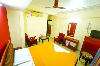 a living room with a yellow table and chairs at AMOGHA RESIDENCY in Mysore