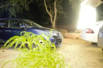 a blue car parked in a parking lot at night at NEW MOUNT RESIDENCY in Sultan Bathery