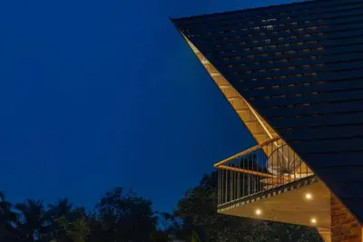 a tall building with a lit up facade at night at Bimal's Casa de Papel in Kadikkād