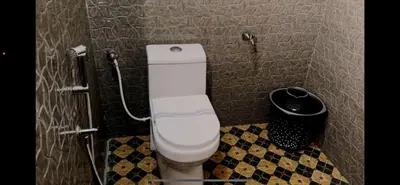 a bathroom with a toilet and a trash can at Easy Inn Wayanad in Kaniyāmbetta
