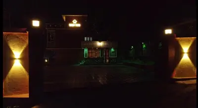 a building with green lights in the dark at Easy Inn Wayanad in Kaniyāmbetta
