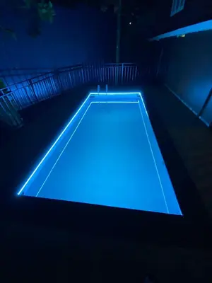 a pool with blue lighting in a dark room at Easy Inn Wayanad in Kaniyāmbetta