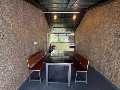 a room with two benches and a table in it at Empire Private Pool Villa in Kalpetta