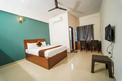 a bedroom with a bed and a television in it at AYANI INN in Mysore