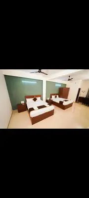 a large room with two beds and a couch at AYANI INN in Mysore