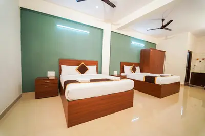 a bedroom with two beds and a green wall at AYANI INN in Mysore