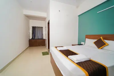 a bedroom with a bed with two towels on it at AYANI INN in Mysore