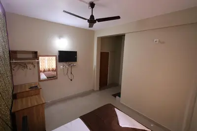 a room with a ceiling fan and a tv on the wall at Wayanad regal residency in Kalpetta