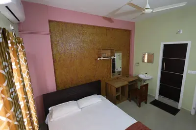 a bedroom with a bed and a bathroom with a sink at Wayanad regal residency in Kalpetta