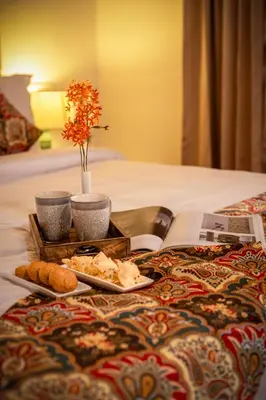 a tray with food and bread on a bed at ama Stays & Trails Skanda , Coorg in Madikeri