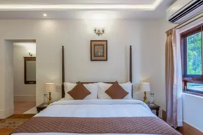 a bedroom with a large bed and a window at ama Stays & Trails Skanda , Coorg in Madikeri