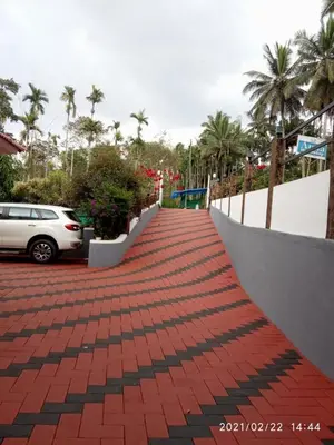 a red brick walkway with a car parked on it at Anna homestay in Chekadi