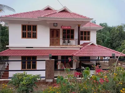 a white house with a red roof at Anna homestay in Chekadi