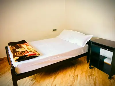 a bed with white sheets and pillows in a room at Anna homestay in Chekadi