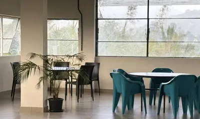 a dining room with a table and chairs and windows at Vythiri Palace Wayanad Pool Resort - Mist Climate & India's First Apple Infinity Pool in Vythiri