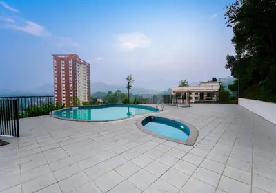 a swimming pool on a patio with a building at Vythiri Palace Wayanad Pool Resort - Mist Climate & India's First Apple Infinity Pool in Vythiri