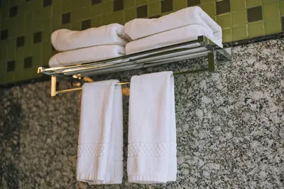 a bathroom with white towels on a towel rack at Elixir Woods Luxury Resort And Spa, Munnar in Munnar