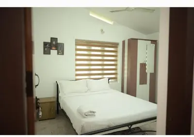a white bed in a room with a window at Chills homestay in Kalpetta