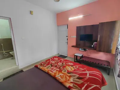 a bedroom with a large bed with a red blanket at Ooty Prakash Residency in Ooty