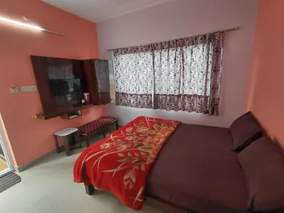 a bedroom with a large bed and a window at Ooty Prakash Residency in Ooty