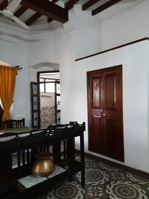 a room with a table and a wooden door at Heritage Home, Hampe's in Mysore