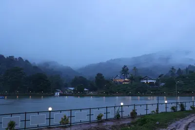 a view of a lake at night with mountains in the background at jungle view resort in Mananthavady