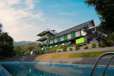 a hotel with a swimming pool in front of a building at jungle view resort in Mananthavady
