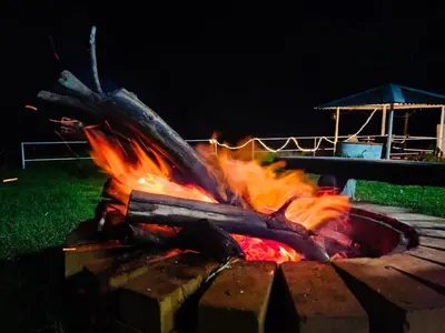 a fire pit in the yard at night at Cloud & Mist Inn-Whole Villa Stay with Mountain Views in Kotagiri, Near Ooty in Kotagiri