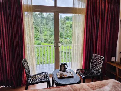 a room with a table and two chairs and a window at Cloud & Mist Inn-Whole Villa Stay with Mountain Views in Kotagiri, Near Ooty in Kotagiri