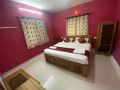 a bedroom with a large bed with red walls at J J HOMES in Ooty