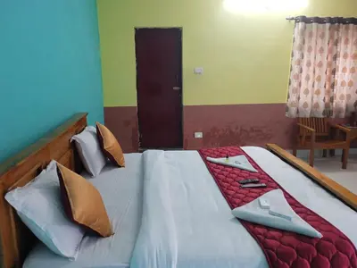 a bedroom with a large bed with pillows on it at J J HOMES in Ooty