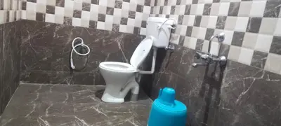 a bathroom with a toilet in a black and white tiles at J J HOMES in Ooty