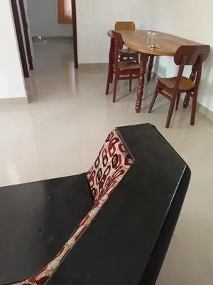 a black bench in a room with a table and chairs at Space villa Homestay in Irimbranallūr