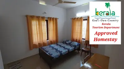 a room with a bed and a sign that reads kerala councils own country at Space villa Homestay in Irimbranallūr
