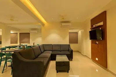 a living room with a couch and a table at Hotel Stay Bella Kozhikode in Kozhikode
