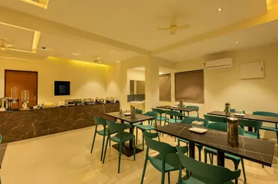 a restaurant with tables and chairs and a bar at Hotel Stay Bella Kozhikode in Kozhikode