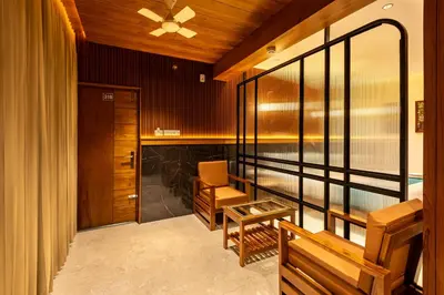 a room with a balcony with a bench and a table at Hotel Stay Bella Kozhikode in Kozhikode