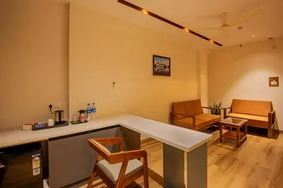 a kitchen with a counter and chairs in a room at Hotel Stay Bella Kozhikode in Kozhikode