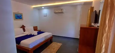 a hotel room with a bed and a tv at Empire Single Bedroom Villa with Common Pool in Meenangadi